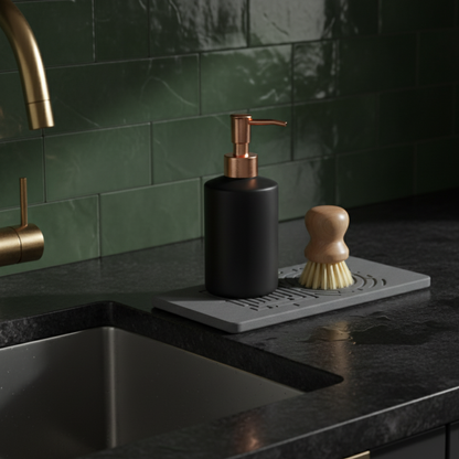 Black soap dispenser and brush on a kitchen counter with green tiles in the background An organized, clutter-free countertop with a diatomaceous earth sink caddy.

