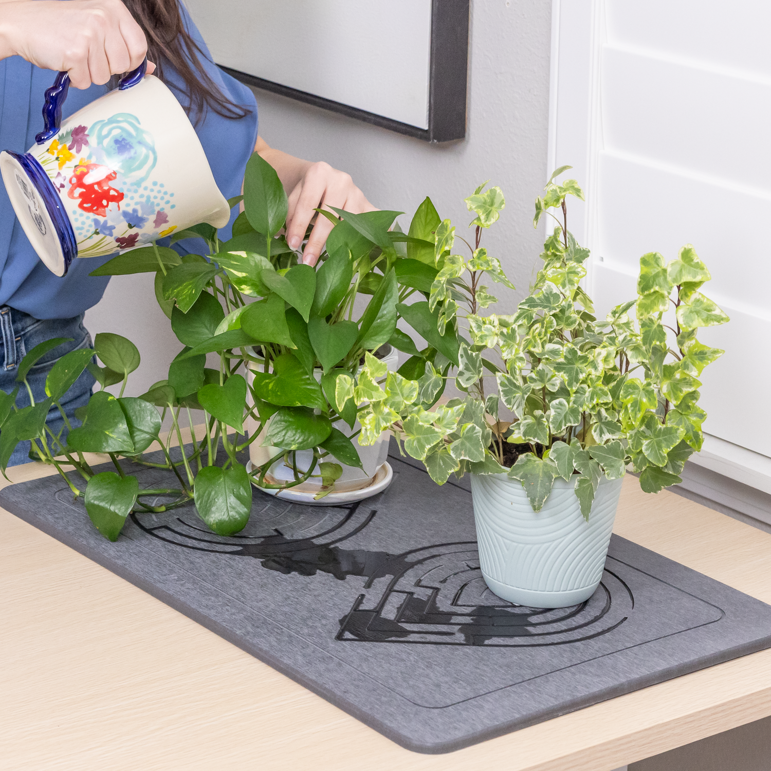 An absorbent diatomaceous earth mat catching water drainage from a houseplant.
